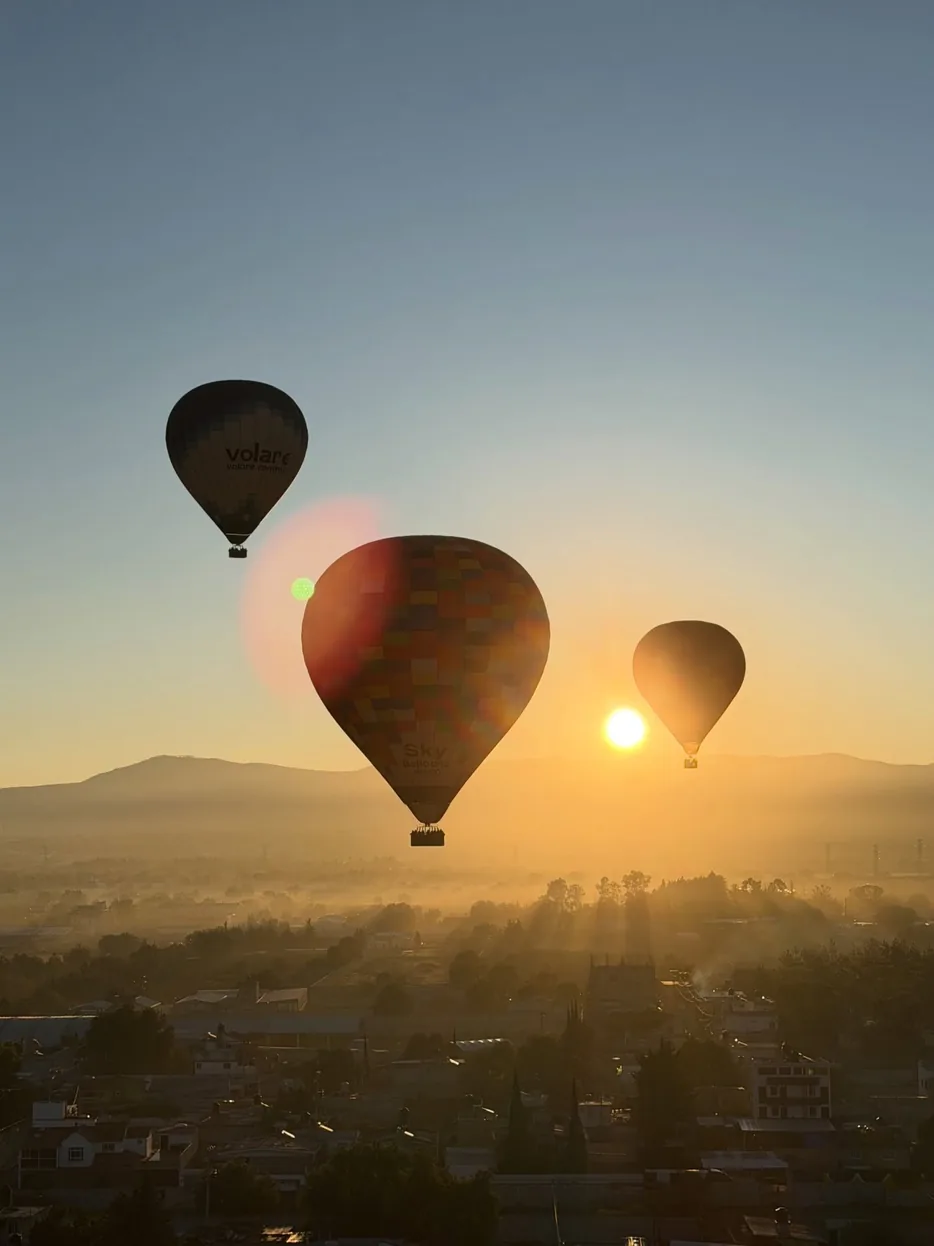 Globo aerostático a contraluz al amanecer sobre el valle de Teotihuacán